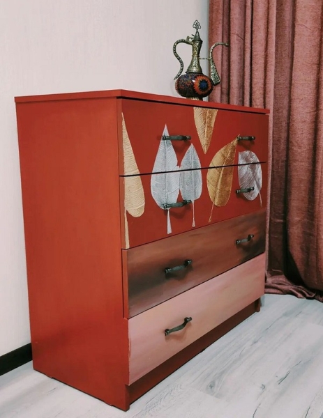 Темний комод з об'ємним золотим візерунком, створеним за допомогою поталі